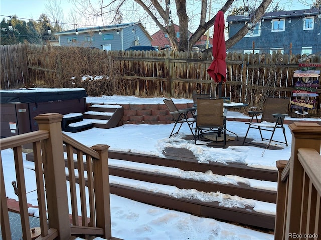 snow covered deck with a hot tub