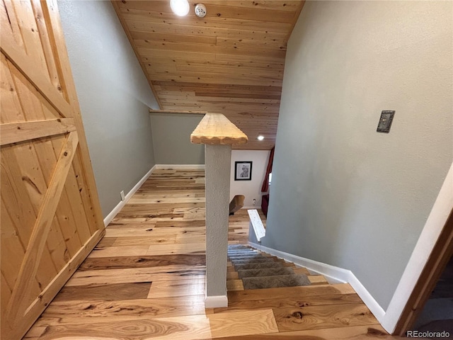 stairs featuring wood-type flooring and wooden ceiling