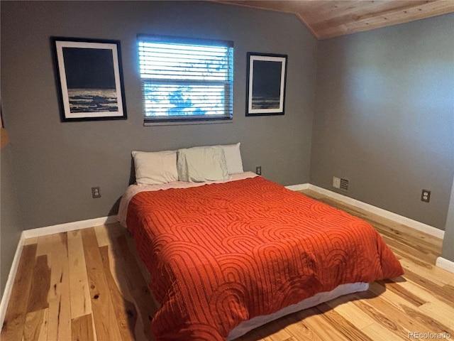 bedroom with lofted ceiling and hardwood / wood-style floors