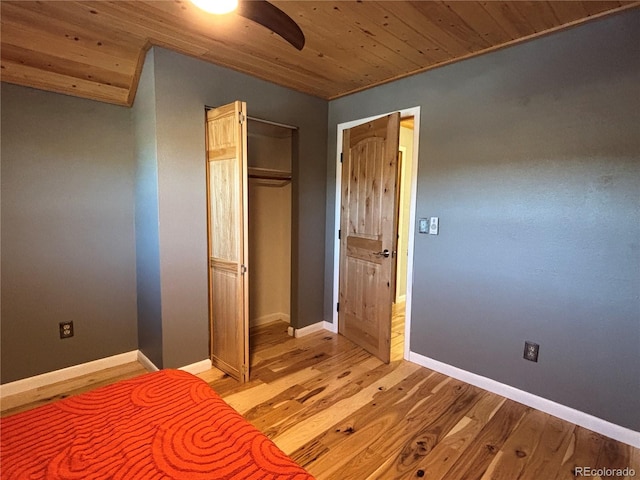 unfurnished bedroom featuring wood ceiling, light hardwood / wood-style flooring, a closet, and ceiling fan