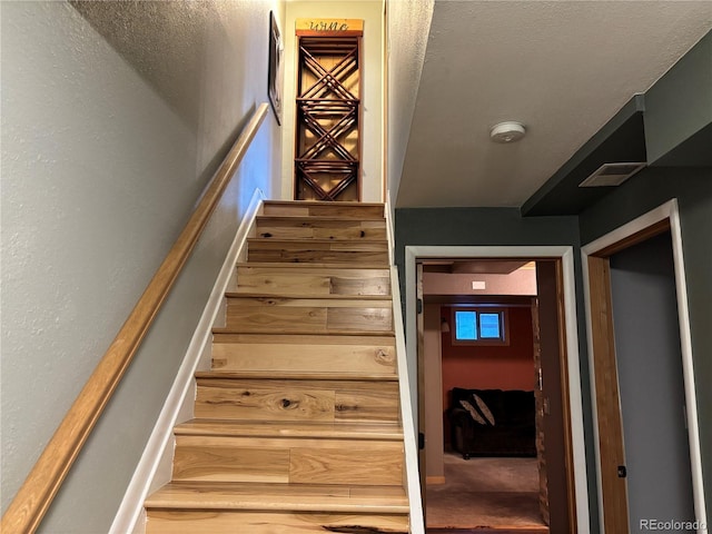 stairway featuring carpet flooring