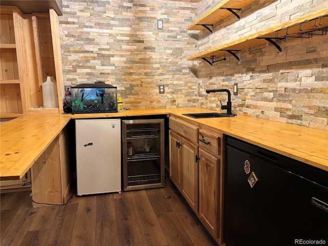 bar with dark hardwood / wood-style floors, refrigerator, butcher block countertops, sink, and beverage cooler