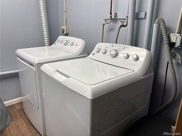 clothes washing area with dark wood-type flooring and washing machine and dryer