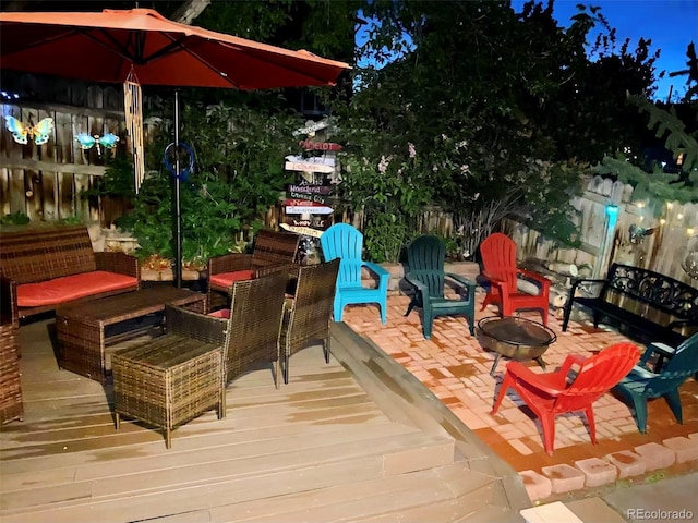 deck featuring an outdoor living space with a fire pit