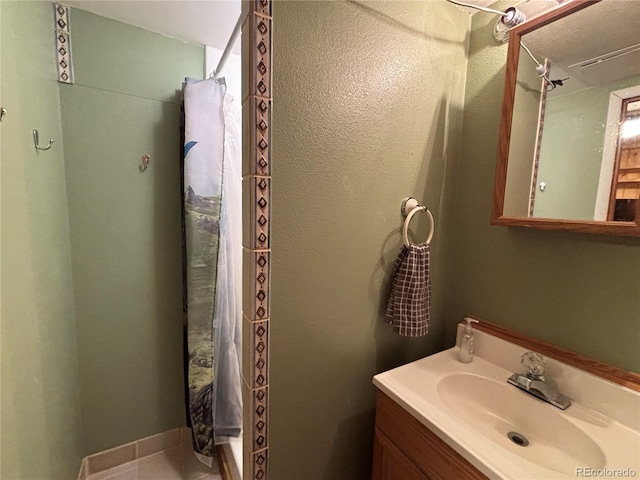 bathroom featuring vanity, tile patterned floors, and walk in shower