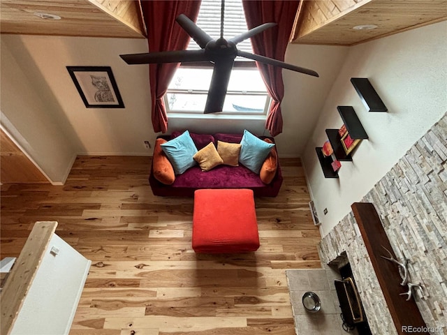 unfurnished living room featuring hardwood / wood-style flooring, a stone fireplace, and wooden ceiling