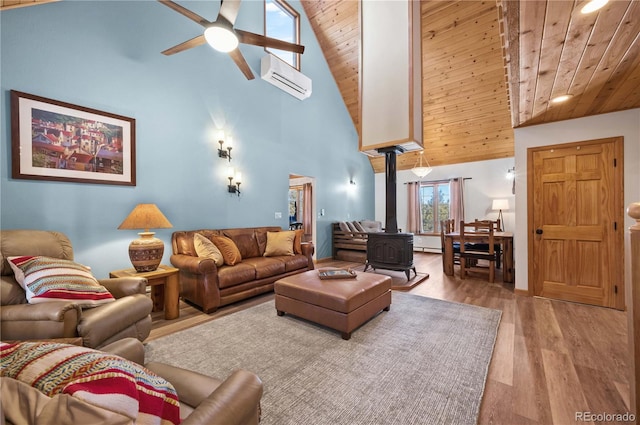 living room featuring ceiling fan, an AC wall unit, wooden ceiling, a wood stove, and wood finished floors