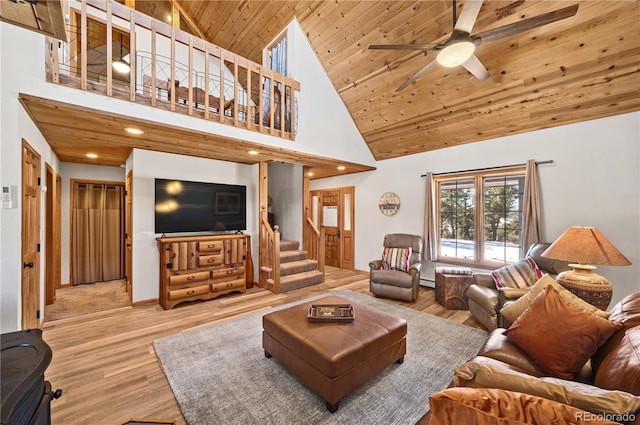 living room featuring wood finished floors, a ceiling fan, high vaulted ceiling, stairs, and wooden ceiling