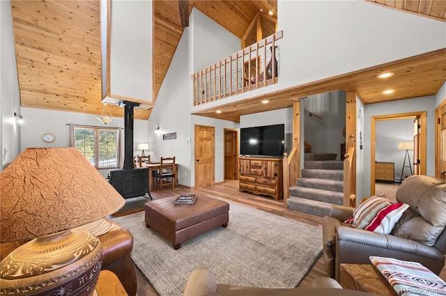 living room featuring stairway, recessed lighting, wooden ceiling, a wood stove, and wood finished floors