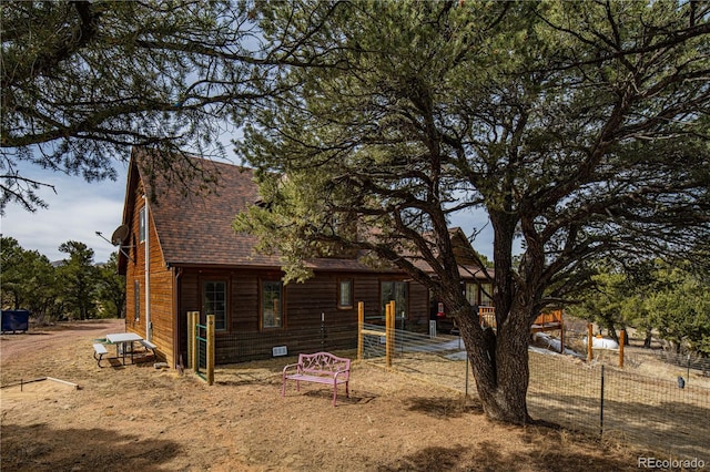 exterior space with fence and a shingled roof