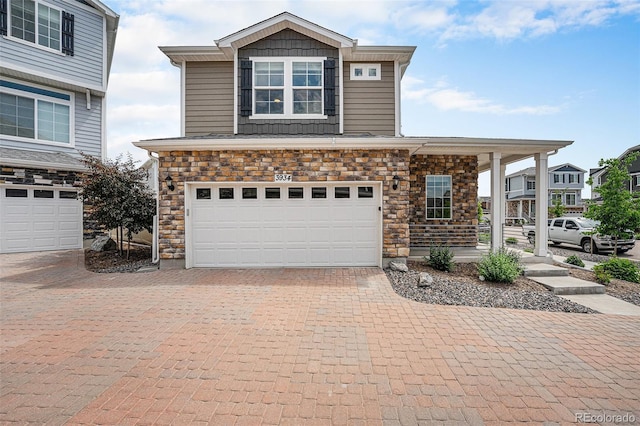 3934 N Quatar Ct, Aurora, CO 80019 - view of front facade featuring an attached garage, decorative driveway, and stone siding
