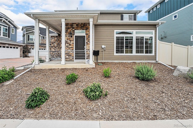 3934 N Quatar Ct, Aurora, CO 80019 - view of front of property featuring covered porch, stone siding, and driveway