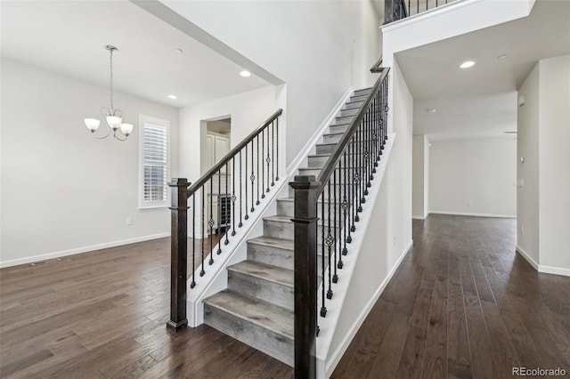 staircase featuring a chandelier and wood-type flooring