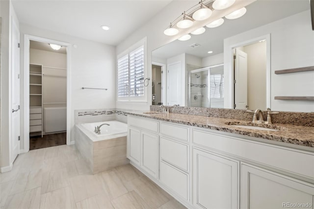 bathroom featuring shower with separate bathtub and vanity