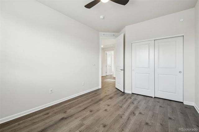 unfurnished bedroom with light wood-type flooring, ceiling fan, and a closet