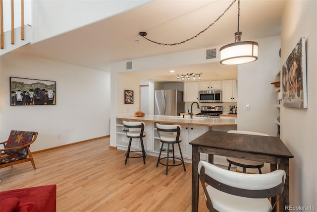 23624 Pondview Pl Unit G, Golden, CO 80401 - kitchen featuring light wood finished floors, stainless steel appliances, a breakfast bar area, a peninsula, and light countertops