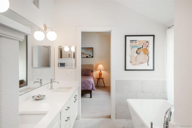 23624 Pondview Pl Unit G, Golden, CO 80401 - ensuite bathroom with double vanity, a freestanding tub, vaulted ceiling, and tile patterned flooring
