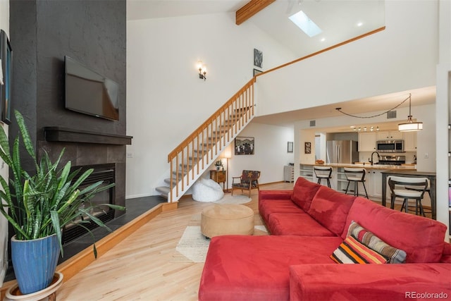 23624 Pondview Pl Unit G, Golden, CO 80401 - living room with stairway, wood finished floors, a tiled fireplace, high vaulted ceiling, and beam ceiling