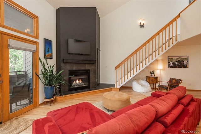 23624 Pondview Pl Unit G, Golden, CO 80401 - living area with high vaulted ceiling, wood finished floors, stairs, and a tiled fireplace