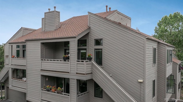 23624 Pondview Pl Unit G, Golden, CO 80401 - view of side of property featuring a chimney, roof with shingles, and a balcony
