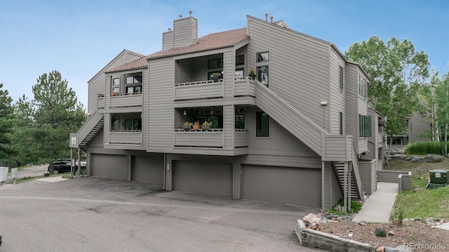 23624 Pondview Pl Unit G, Golden, CO 80401 - rear view of property with a garage, a balcony, a chimney, and driveway