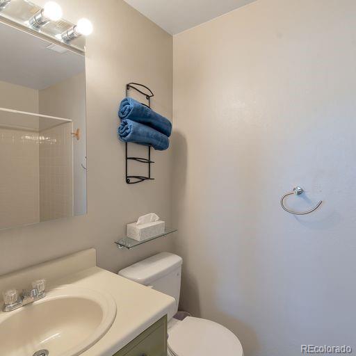 full bathroom with a shower, toilet, and vanity