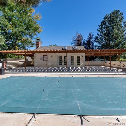 back of house with french doors, a pergola, fence, and a chimney