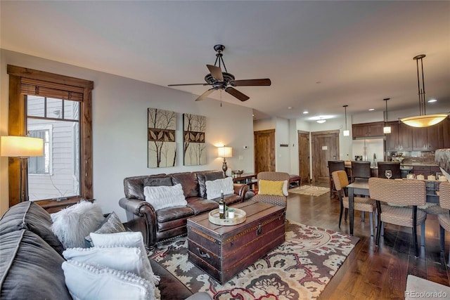 living room featuring ceiling fan and dark hardwood / wood-style floors