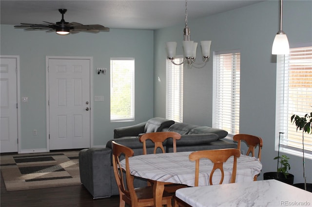 dining space featuring healthy amount of natural light, a chandelier, ceiling fan, and dark wood finished floors