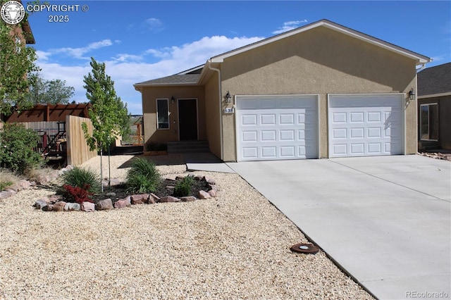 view of front of house featuring stucco siding, a garage, and driveway