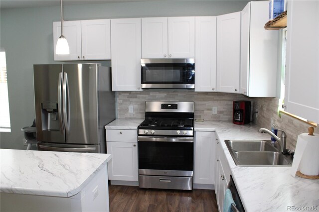 kitchen featuring stainless steel appliances, a sink, and white cabinetry