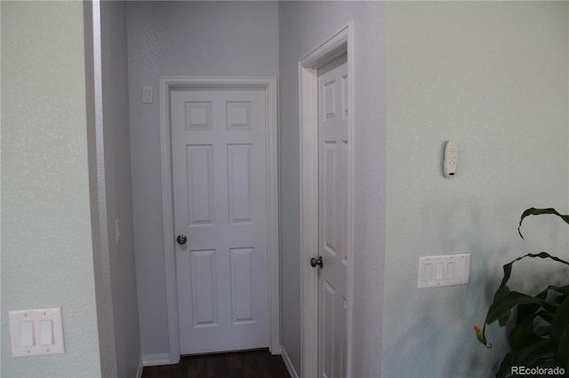 hall with dark wood finished floors and baseboards