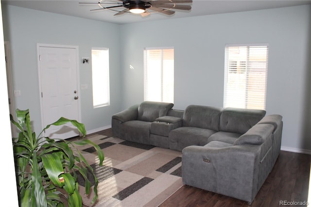 living room featuring ceiling fan, plenty of natural light, dark wood-type flooring, and baseboards