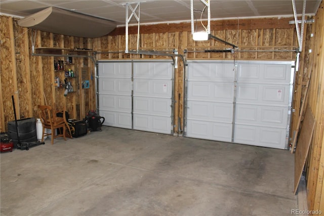 garage with wood walls and a garage door opener