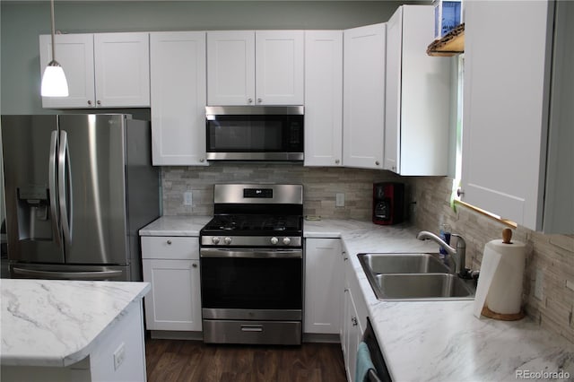 kitchen featuring stainless steel appliances, a sink, and white cabinets