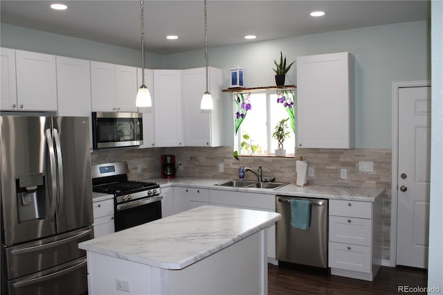 kitchen featuring stainless steel appliances, a sink, a center island, white cabinets, and recessed lighting