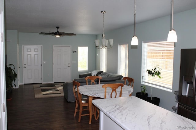 dining room with dark wood finished floors, a ceiling fan, and a chandelier