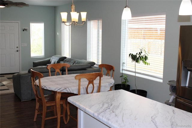 dining space with dark wood-style flooring and a chandelier