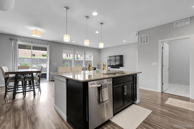 19210 E Pacific Pl, Aurora, CO 80013 - kitchen with stainless steel dishwasher, dark cabinetry, recessed lighting, wood finished floors, and an island with sink