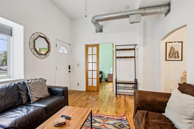 915 26th St, Denver, CO 80205 - living area featuring light wood-style floors, a high ceiling, and arched walkways