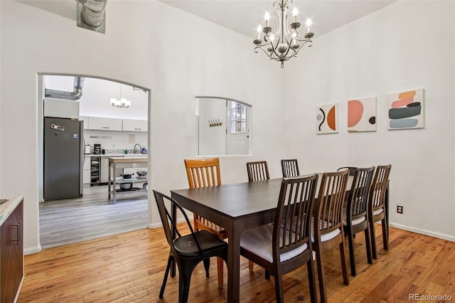 915 26th St, Denver, CO 80205 - dining room featuring a chandelier, light wood-style flooring, and a high ceiling
