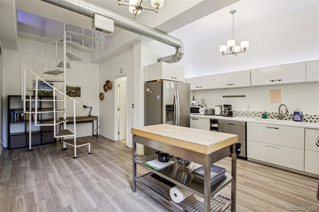 915 26th St, Denver, CO 80205 - kitchen featuring a chandelier, appliances with stainless steel finishes, a high ceiling, light countertops, and light wood finished floors