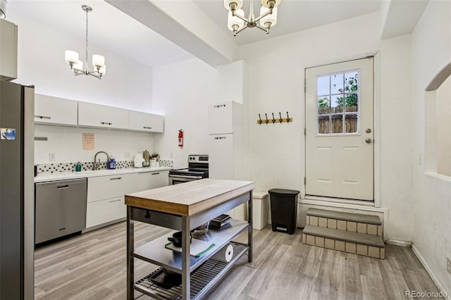 915 26th St, Denver, CO 80205 - kitchen with a chandelier, stainless steel appliances, light countertops, and light wood-style floors