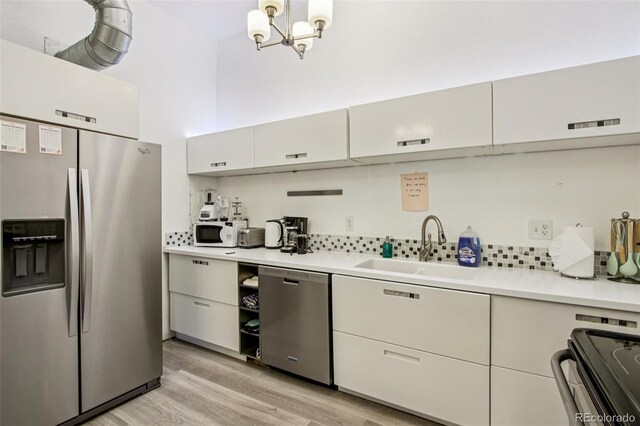 915 26th St, Denver, CO 80205 - kitchen featuring appliances with stainless steel finishes, light countertops, light wood-style flooring, and decorative backsplash