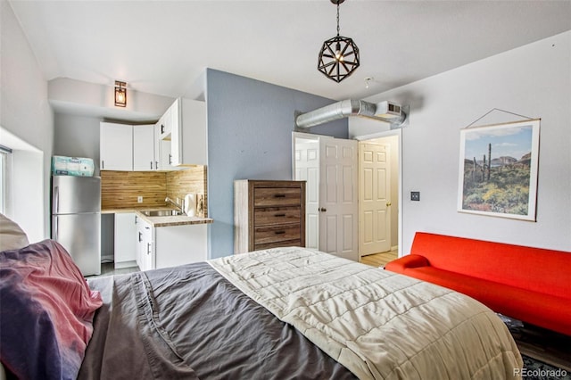 915 26th St, Denver, CO 80205 - bedroom featuring refrigerator, light wood-style flooring, and vaulted ceiling