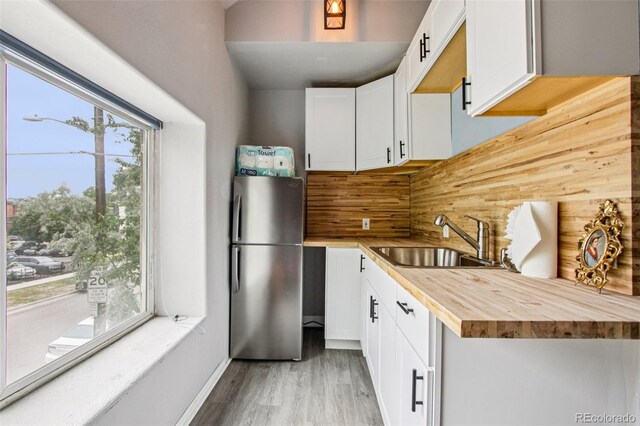 915 26th St, Denver, CO 80205 - kitchen featuring freestanding refrigerator, wood counters, light wood-style floors, backsplash, and white cabinetry