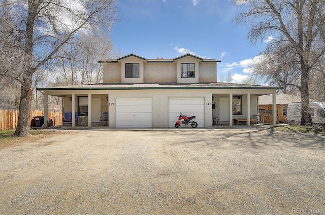 traditional-style home with fence, an attached garage, stucco siding, a porch, and driveway