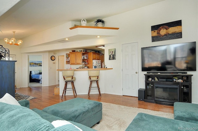 living room with recessed lighting, light wood finished floors, and a notable chandelier