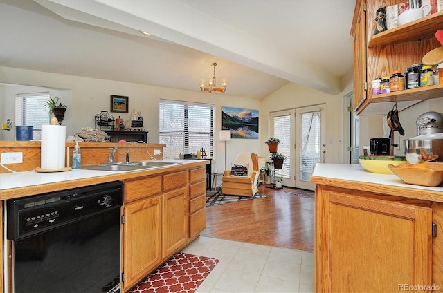 kitchen featuring a wealth of natural light, black dishwasher, light countertops, a sink, and vaulted ceiling