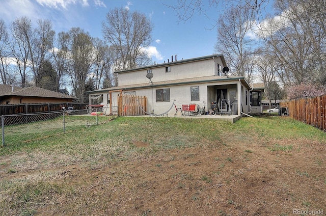back of property featuring a lawn, a fenced backyard, a patio area, and stucco siding